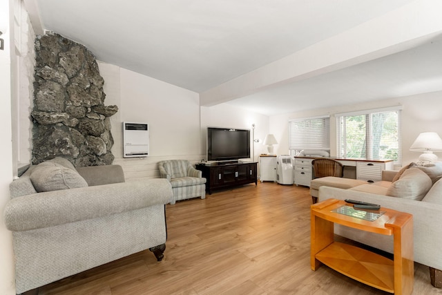 living room featuring lofted ceiling, heating unit, and light wood-type flooring