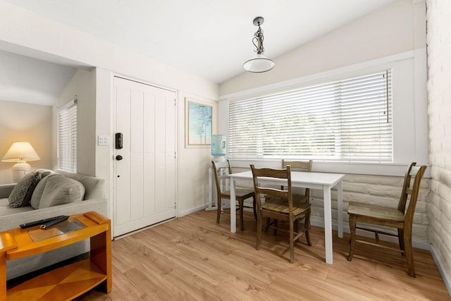 dining space featuring lofted ceiling and light hardwood / wood-style flooring