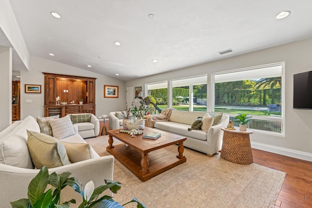 living room with vaulted ceiling and light hardwood / wood-style floors