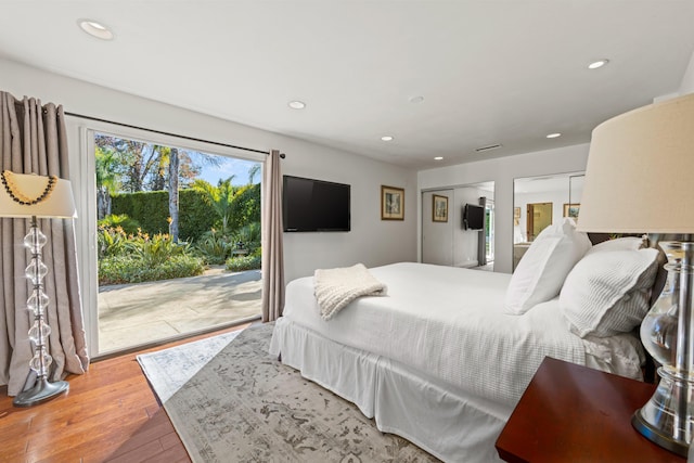 bedroom featuring wood-type flooring and access to outside