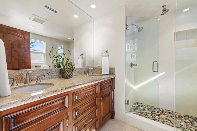 bathroom featuring vanity, tile patterned flooring, and a shower with door