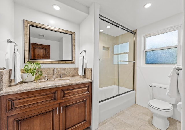 full bathroom featuring toilet, vanity, bath / shower combo with glass door, and tile patterned flooring