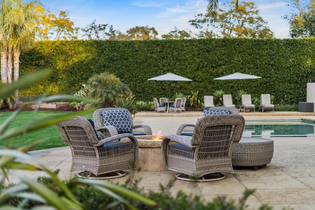 view of patio featuring a fenced in pool and a fire pit