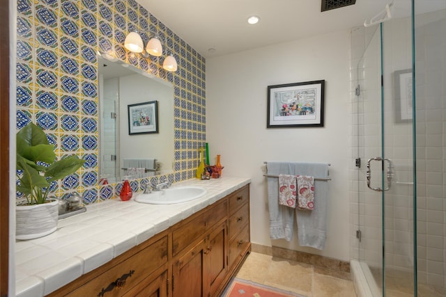 bathroom featuring vanity and a shower with door