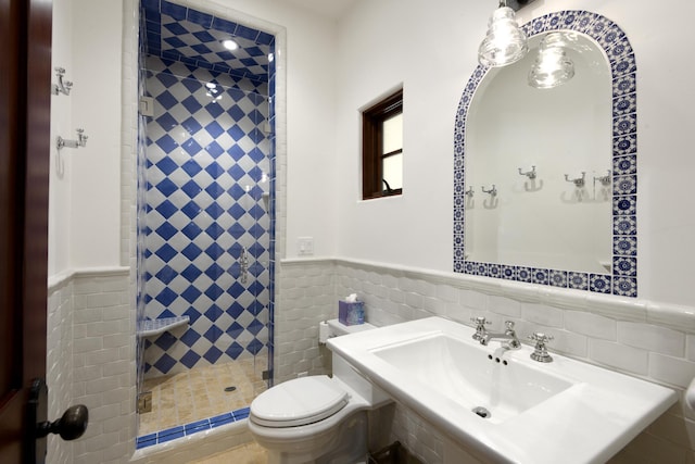 bathroom featuring toilet, an enclosed shower, and tile walls