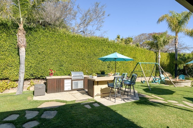 view of yard with an outdoor kitchen, a playground, an outdoor bar, and a patio