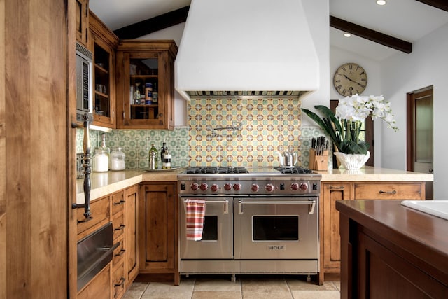 kitchen with backsplash, vaulted ceiling with beams, custom range hood, and appliances with stainless steel finishes