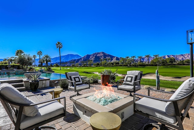 view of patio / terrace with an outdoor fire pit and a mountain view