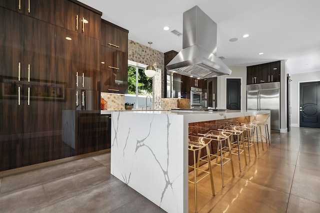 kitchen with a center island, stainless steel appliances, sink, island range hood, and a breakfast bar area