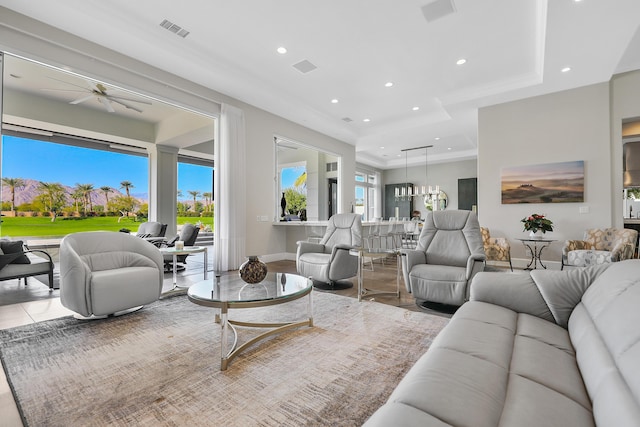 living room with ceiling fan and a raised ceiling