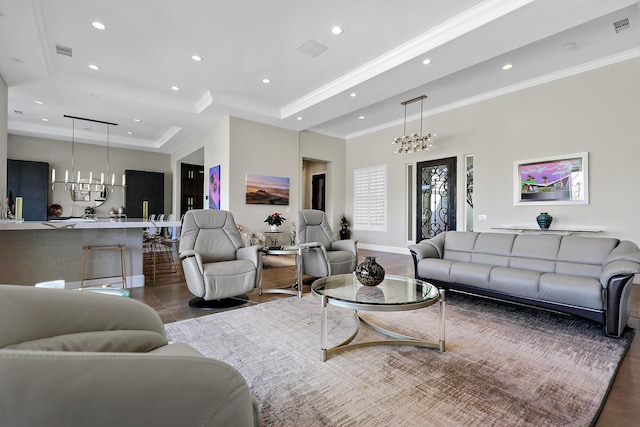 living room with a tray ceiling and a notable chandelier