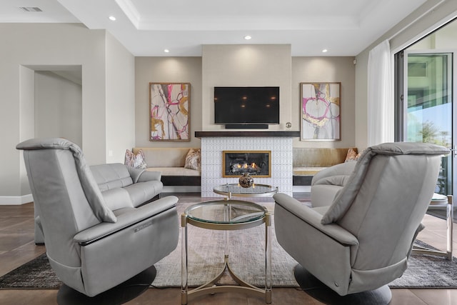 living room featuring a raised ceiling and ornamental molding