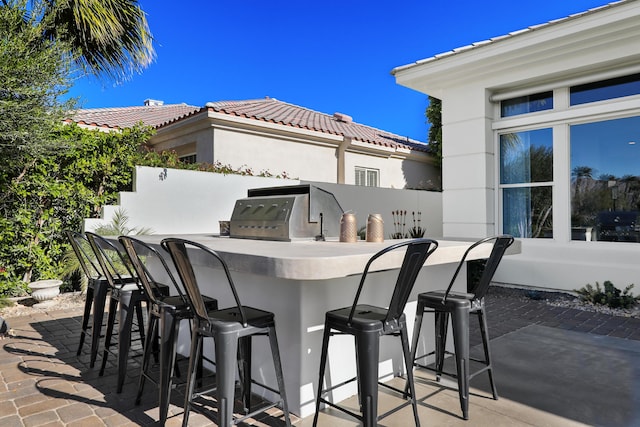 view of patio with an outdoor bar and area for grilling