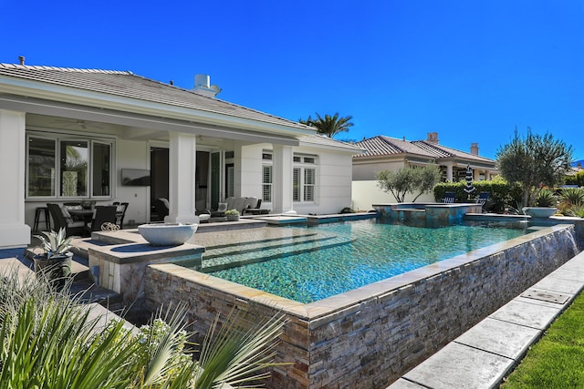 view of pool with ceiling fan, a jacuzzi, and a patio