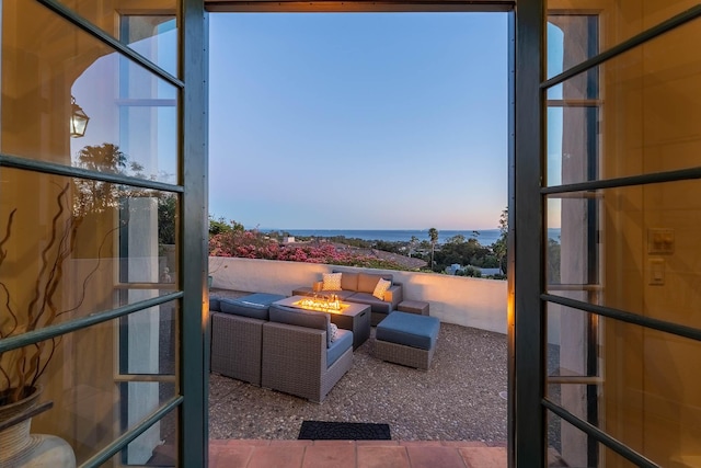 exterior space featuring a patio area, an outdoor fire pit, and a water view