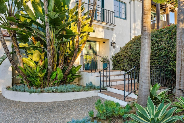 doorway to property with stucco siding and a balcony