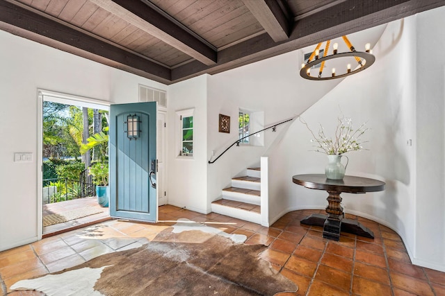 entryway featuring visible vents, a chandelier, stairs, beam ceiling, and wooden ceiling