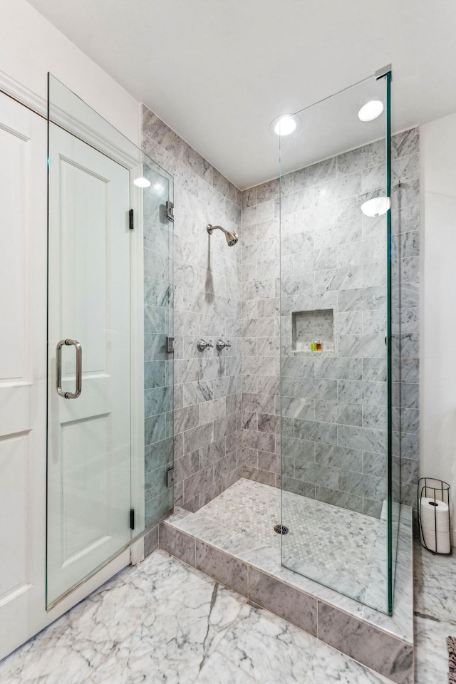 full bath featuring marble finish floor and a stall shower