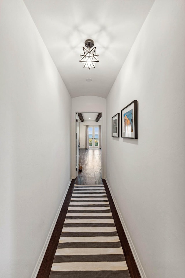 hall with baseboards and wood finished floors