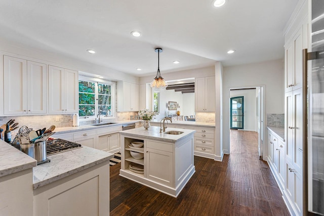 kitchen with a sink, white cabinets, and dark wood-style flooring