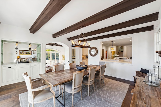 dining space featuring beamed ceiling, arched walkways, dark wood-style flooring, and french doors