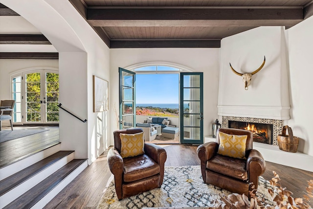 living area with a fireplace, plenty of natural light, french doors, and wood-type flooring