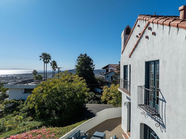 view of side of property featuring a balcony and stucco siding