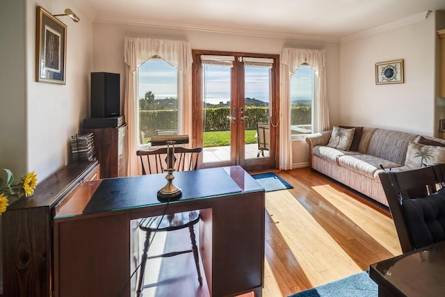 living room featuring french doors, ornamental molding, and light wood-type flooring