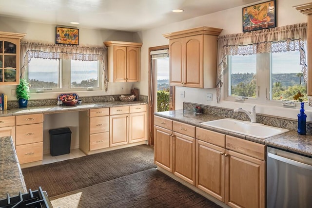 kitchen with stainless steel dishwasher, built in desk, sink, and light brown cabinets