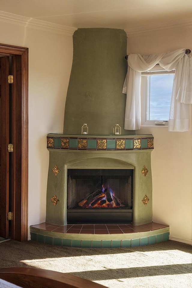 details featuring crown molding, a tile fireplace, and carpet