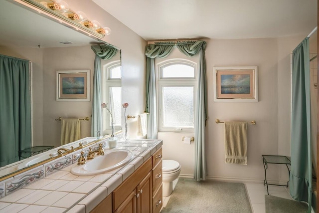 bathroom with tile patterned flooring, vanity, and toilet