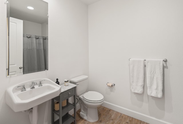 bathroom with wood-type flooring, sink, and toilet