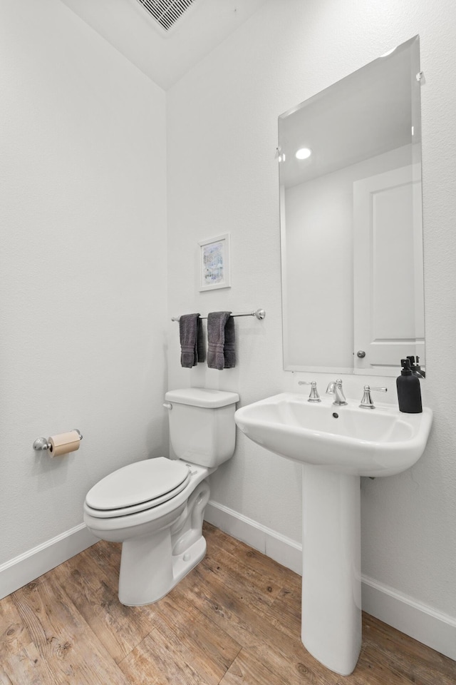 bathroom featuring sink, hardwood / wood-style floors, and toilet