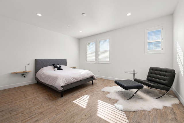 bedroom with multiple windows and hardwood / wood-style floors