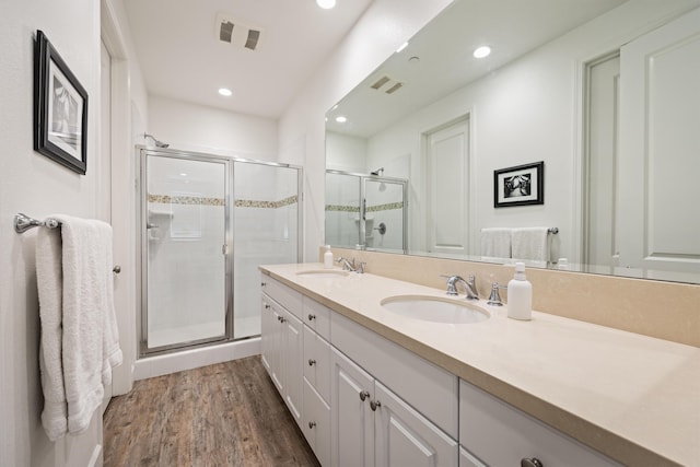 bathroom featuring vanity, hardwood / wood-style flooring, and a shower with door