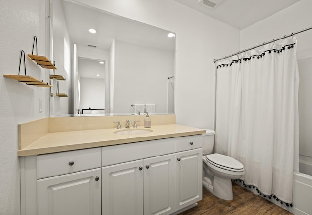 full bathroom featuring vanity, wood-type flooring, shower / bathtub combination with curtain, and toilet