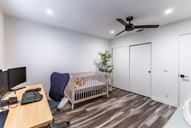 bedroom with dark wood-type flooring, ceiling fan, and a closet