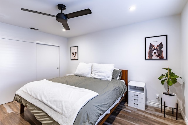 bedroom with ceiling fan, hardwood / wood-style floors, and a closet