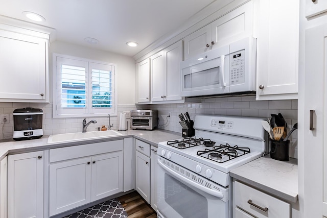 kitchen featuring sink, dark hardwood / wood-style floors, white cabinets, white appliances, and backsplash