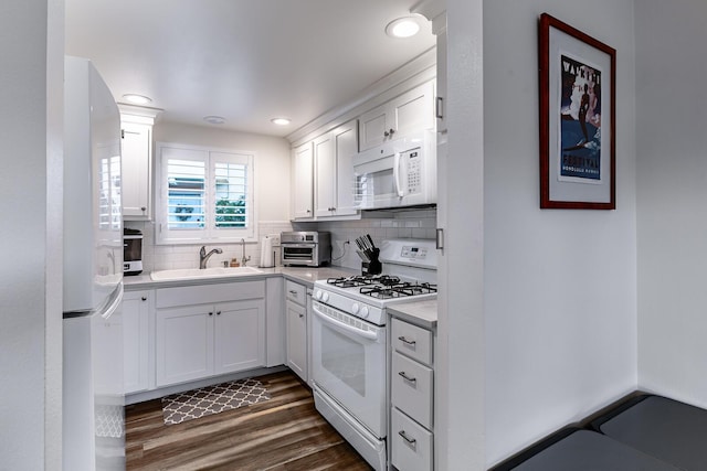 kitchen with sink, dark hardwood / wood-style floors, white appliances, decorative backsplash, and white cabinets