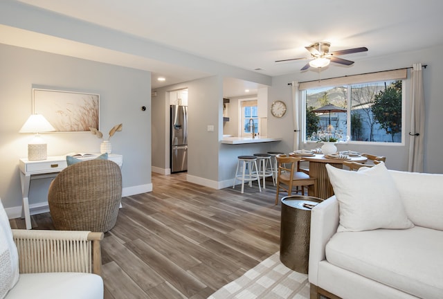 living room with wood-type flooring and ceiling fan