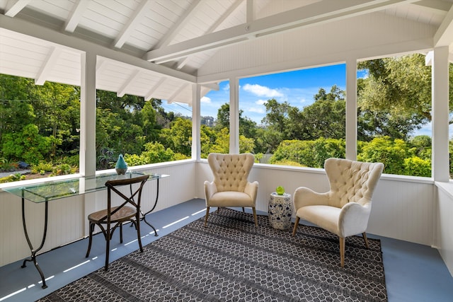 sunroom featuring lofted ceiling with beams