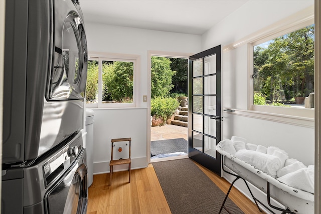 doorway to outside featuring stacked washing maching and dryer, wood-type flooring, and french doors