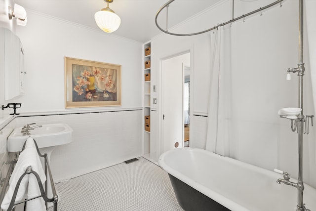 bathroom featuring tile walls, built in features, crown molding, and tile patterned flooring