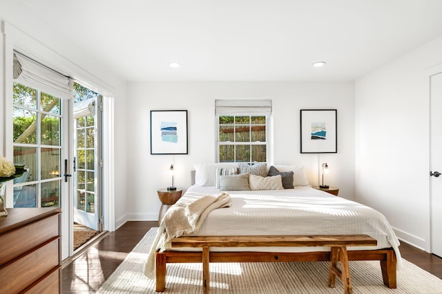 bedroom with access to exterior, dark hardwood / wood-style flooring, and multiple windows