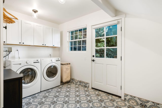 clothes washing area with washer and clothes dryer and cabinets