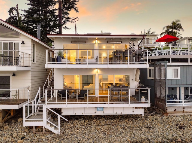 back house at dusk with a balcony