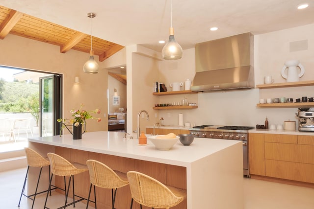 kitchen featuring beamed ceiling, a kitchen island with sink, wall chimney exhaust hood, and wooden ceiling