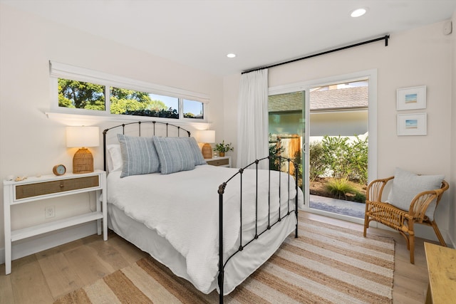 bedroom featuring access to exterior and light wood-type flooring