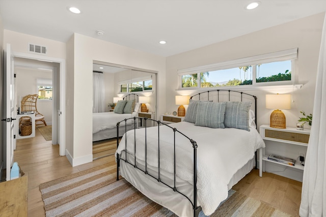 bedroom featuring wood-type flooring and multiple windows